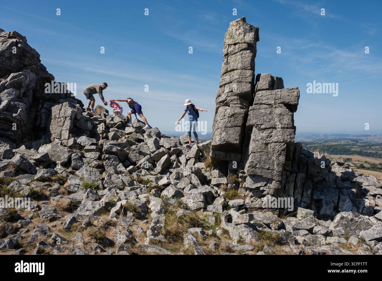 Visiteurs grimpant sur le Manstone Rock, Stiperstones, Shropshire, Angleterre Banque D'Images