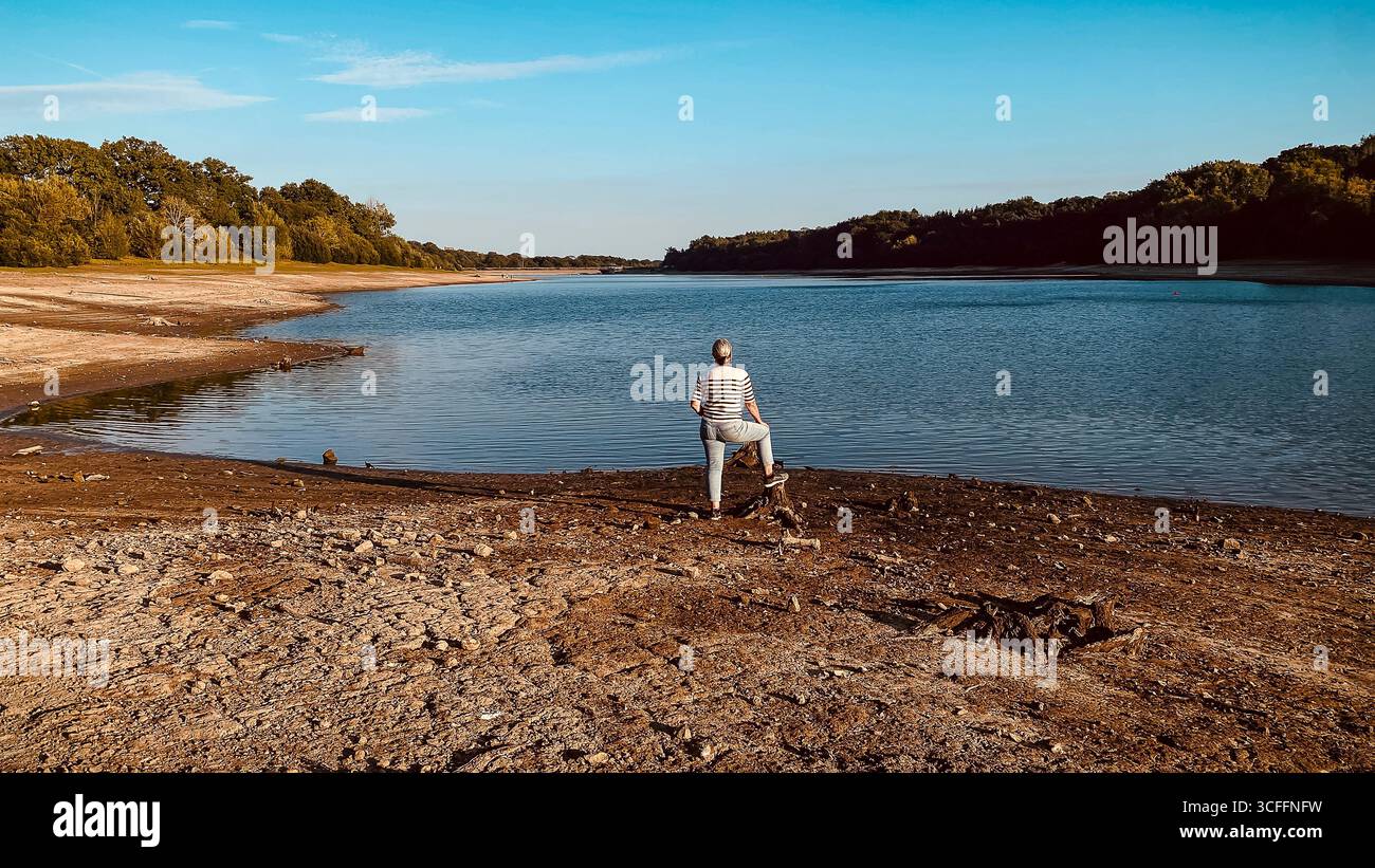 Ardingly Reservoir Sussex 2025, Une femme solitaire regardant sur un espace aride le 22 août, Un réservoir sec après l'été le plus chaud jamais enregistré au Royaume-Uni. - Image de stock capturée avec un smartphone