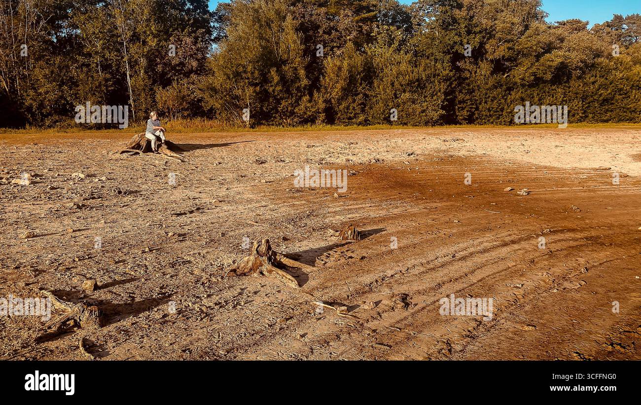 Réservoir Ardingly dans le Sussex de l'Ouest. 22 août 2025, réservoir aride et sec, femelle regardant sur une zone épuisée après l'été le plus chaud sur record UK - Image de stock capturée avec un smartphone