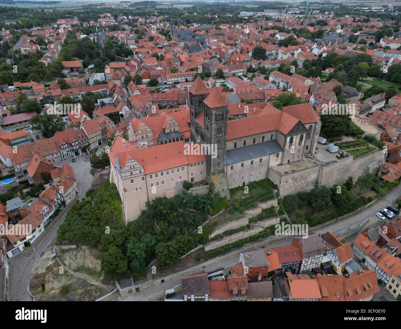 Quedlinburg, Allemagne. 19 août 2025. Vue sur la collégiale de préparServatius avec le musée du château. Une nouvelle exposition muséale est en cours de création avec une galerie de portraits à grande échelle des abbesses de l'abbaye séculaire de 936 à 1802. Les femmes âgées de 15 à 75 ans sont recherchées pour être photographiées pour un portrait historique. Les images seront ensuite traitées numériquement afin de représenter l'abbesse respective de manière réaliste. (Photo aérienne avec un drone) crédit : Matthias Bein/dpa/Alamy Live News Banque D'Images