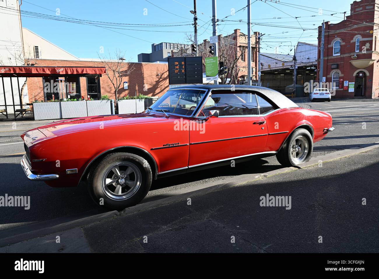 Vue latérale d'une Chevrolet Camaro 327 Rally Sport rouge garée à l'extérieur d'un dépôt de tramway dans la banlieue de Melbourne Banque D'Images