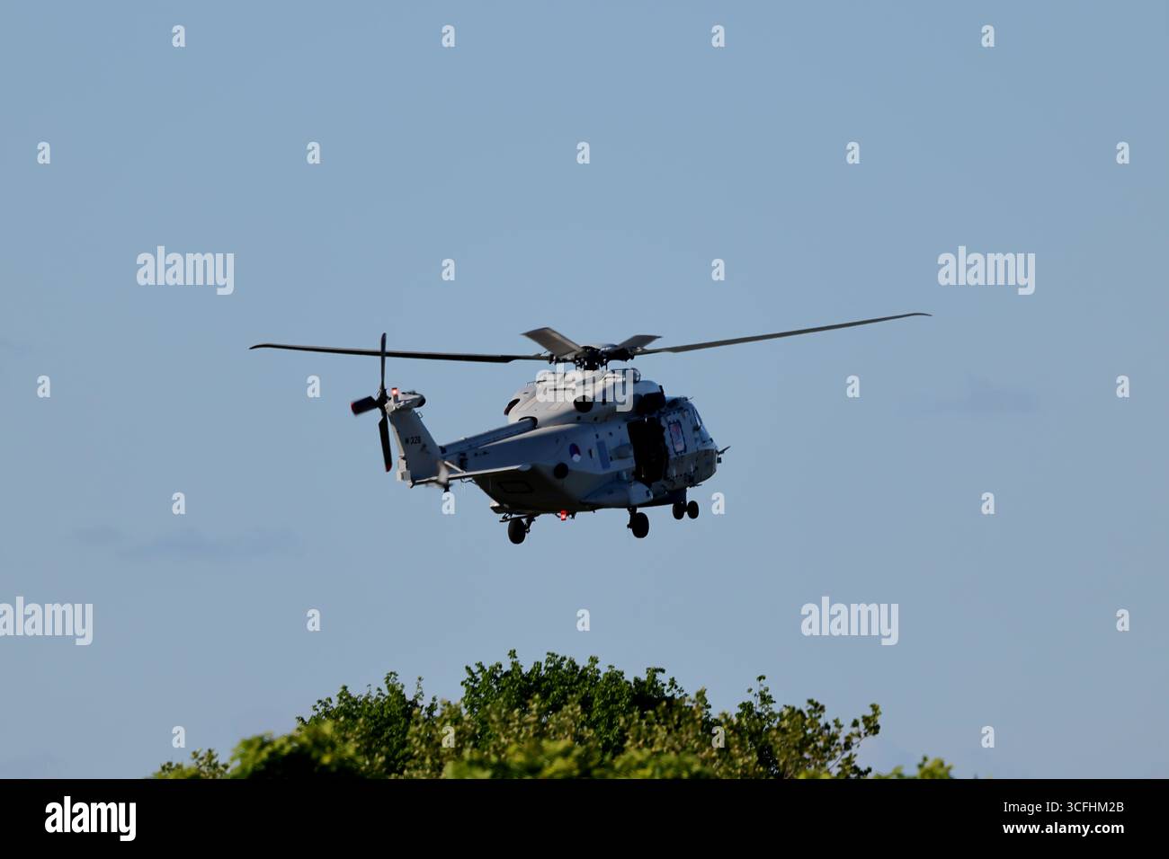 Royal Netherlands Navy NH90 N-326 basse au-dessus d'Amsterdam, pays-Bas, hélicoptère maritime gris avec train d'atterrissage au-dessus de la cime des arbres en plein jour. Banque D'Images