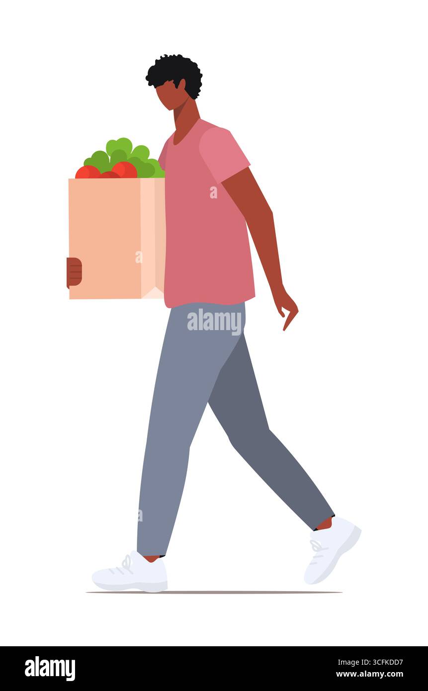 Homme afro-américain tenant un sac d'épicerie en papier réutilisable plein de légumes, de légumes verts, de produits alimentaires. Style de vie et shopping responsables et respectueux de l'environnement. VE Banque D'Images