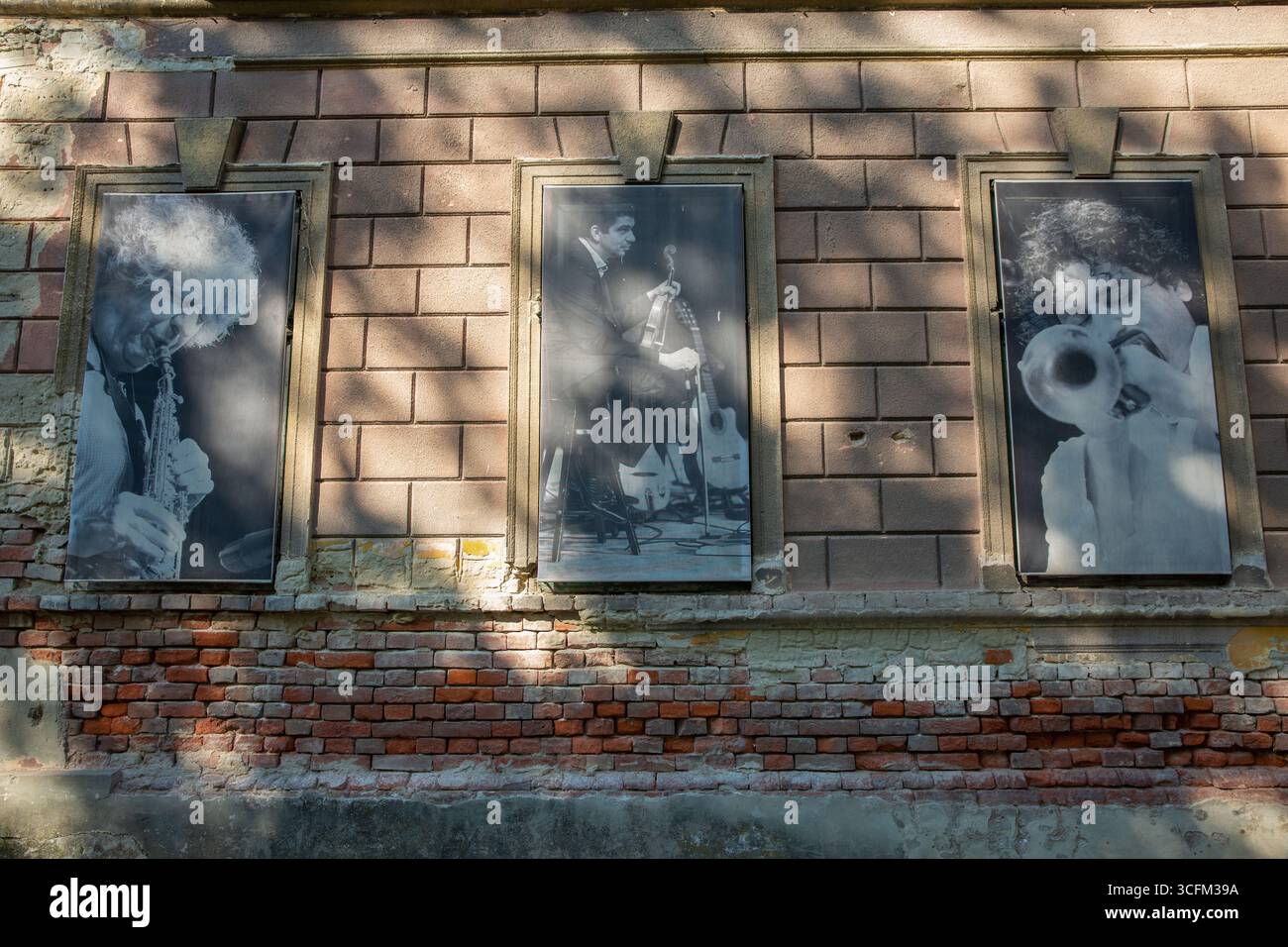 Nagykanizsa, Hongrie - 18 mai 2025 : bâtiment de musée néoclassique avec de grandes photographies de portraits de musiciens de jazz exposés dans les fenêtres, Météo Banque D'Images