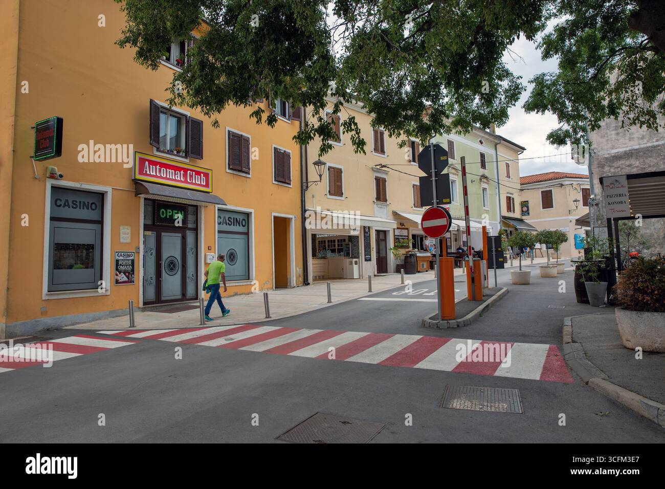 Novigrad, Croatie - 22 mai 2025 : casino Automat Club et entreprises locales le long de la rue piétonne. Architecture méditerranéenne avec fenêtres à volets Banque D'Images