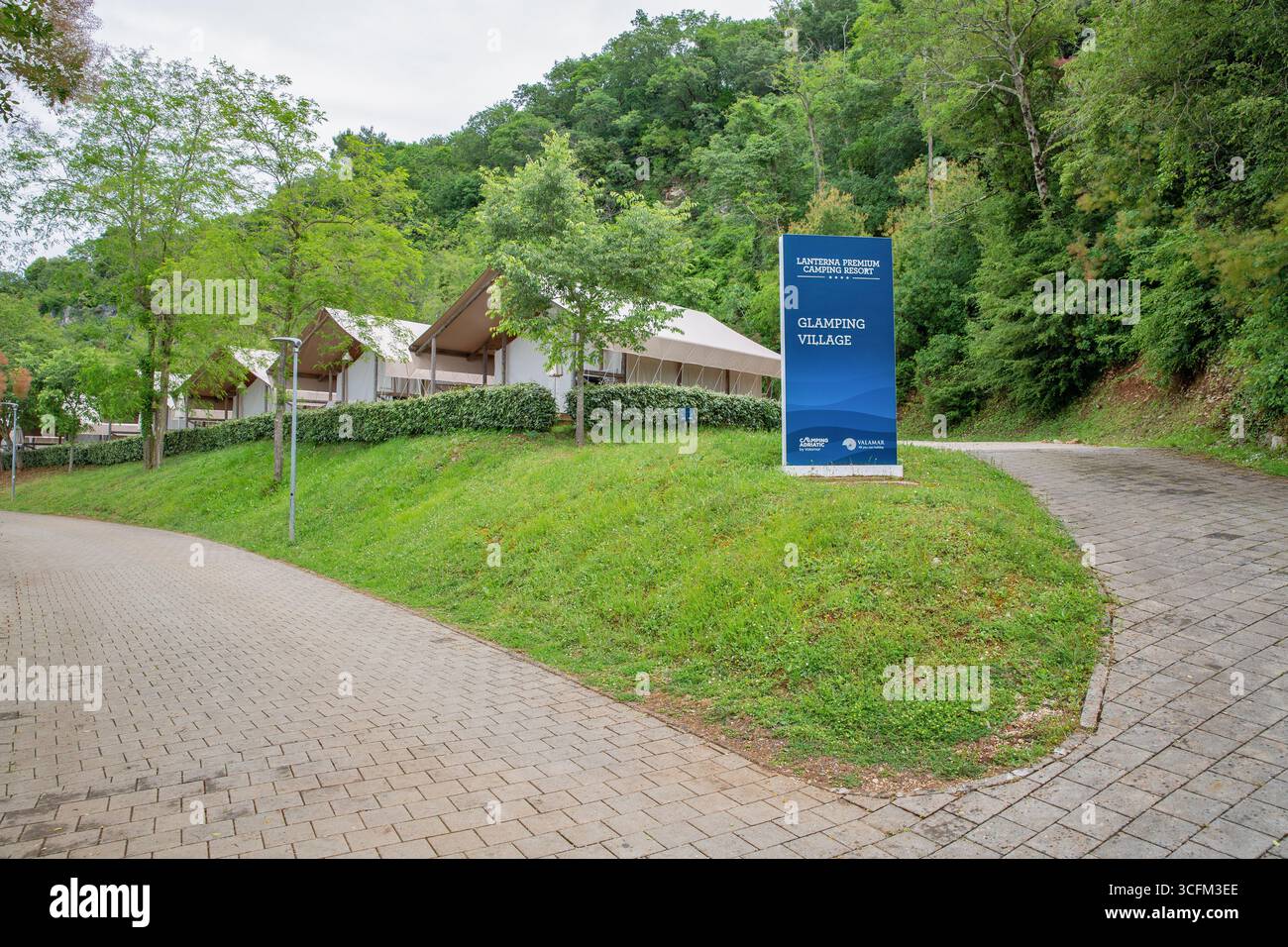Tar, Croatie - 23 mai 2025 : entrée au village de glamping Valamar Lanterna Premium Camping Resort avec panneau d'information bleu et tentes safari de luxe i. Banque D'Images