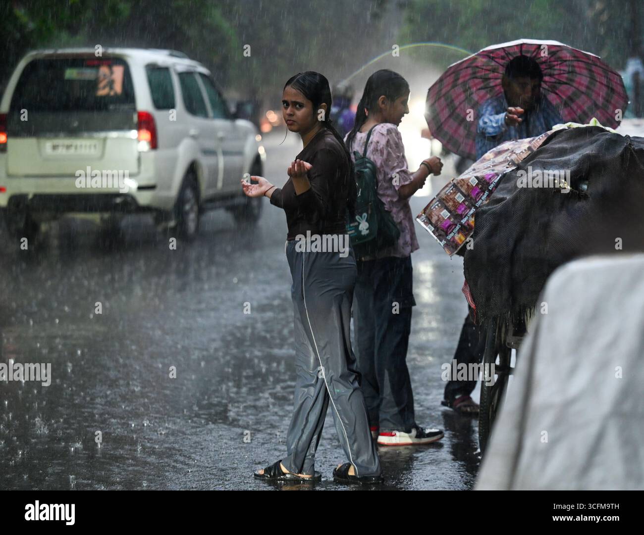 NOIDA, INDE - 23 AOÛT : les navetteurs ont dû faire face à la pluie dans la soirée, le 23 août 2025 à Noida, Inde. Selon le Département météorologique indien (IMD), le ciel d'aujourd'hui sera principalement couvert à Delhi, avec une ou deux périodes de lumière à modérée de pluie ou d'orages dans de nombreux endroits. Dans des endroits isolés, une période intense peut se produire dans l'après-midi ou le forenoon. (Photo de Sunil Ghosh/Hindustan Times/Sipa USA ) crédit : Sipa USA/Alamy Live News Banque D'Images