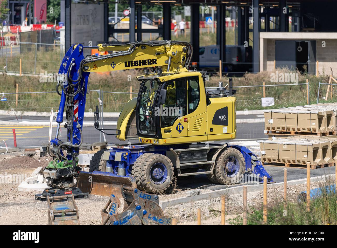 Wickrange, Luxembourg - vue sur une pelle sur roues jaune Liebherr A 918 Compact pour travaux de terrassement sur un chantier. Banque D'Images