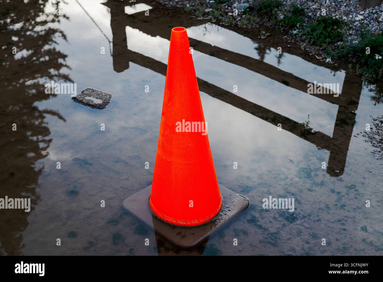 Cône orange dans une flaque d'eau. Banque D'Images