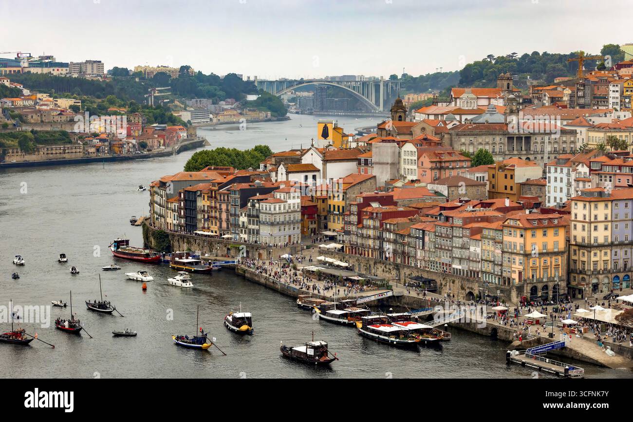 La place Ribeira et le front de mer de Cais da Ribeira, sur le fleuve Douro à Porto, Portugal, avec le pont Ponte da Arrábida en arrière-plan Banque D'Images