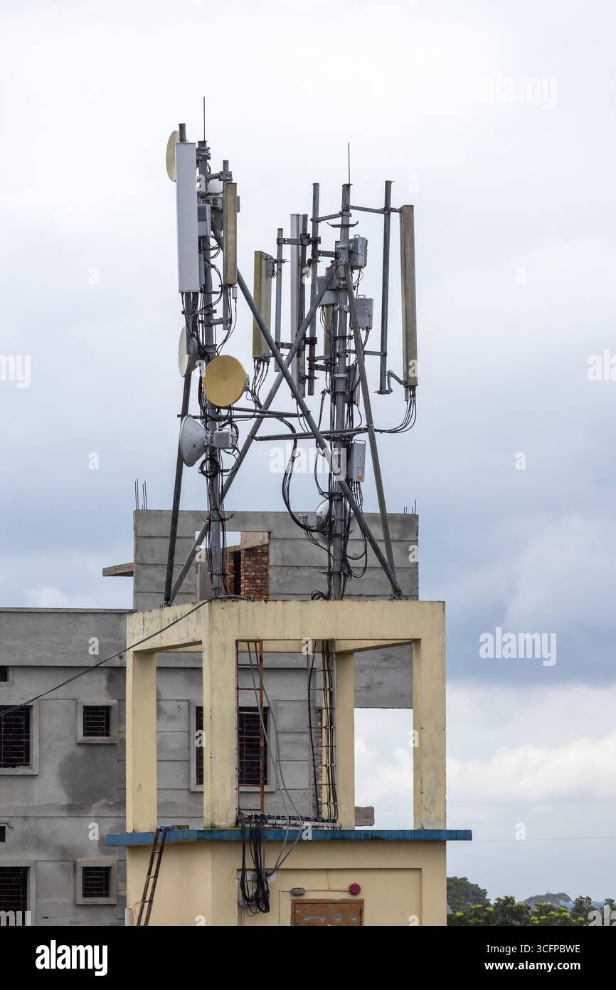 Tour de signal de réseau mobile sur le toit d'un immeuble résidentiel urbain au Bangladesh. Technologie de télécommunication, connectivité Internet 5G et in Banque D'Images