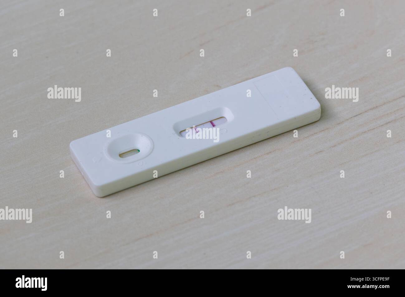 Kit de test de l'hormone lutéinisante (LH) montrant un résultat positif avec deux lignes sur fond de bois. Ce test d'ovulation à domicile aide les femmes à identifier leur M. Banque D'Images