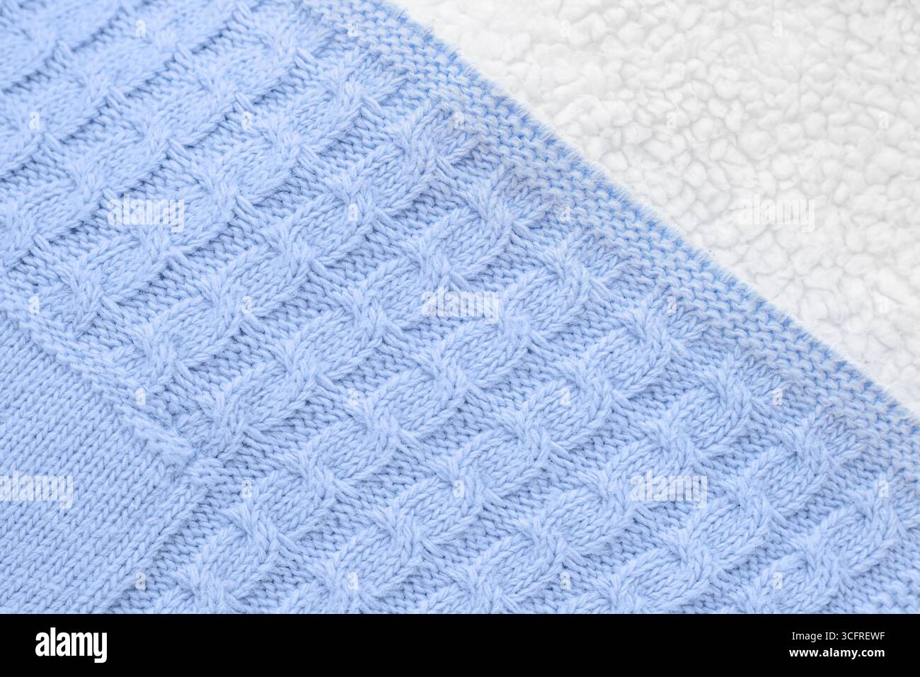 Tricot bleu texturé gros plan avec laine d'agneau blanche à l'arrière, vue de dessus. Couverture d'hiver bébé pour nouveau-nés Banque D'Images