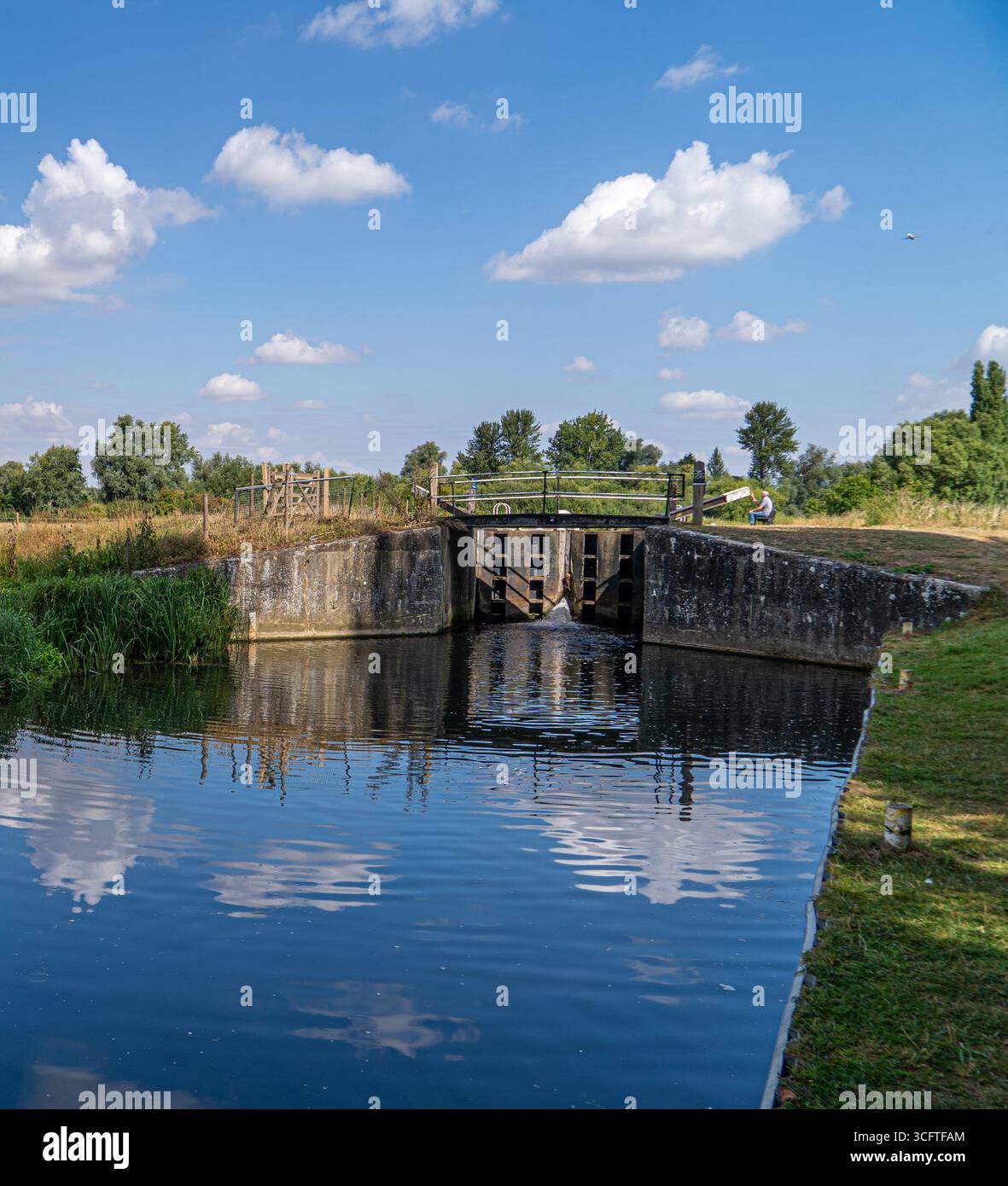 Scène estivale lumineuse d'écluses de canal, roseaux et surface miroitante Banque D'Images