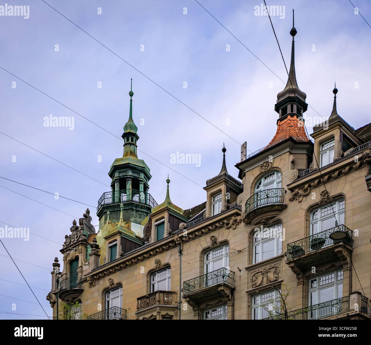 Les tourelles ornées et les balcons d'un bâtiment néo-baroque historique avec des détails classiques contre un ciel nuageux dans le centre-ville de Zurich, Suisse Banque D'Images
