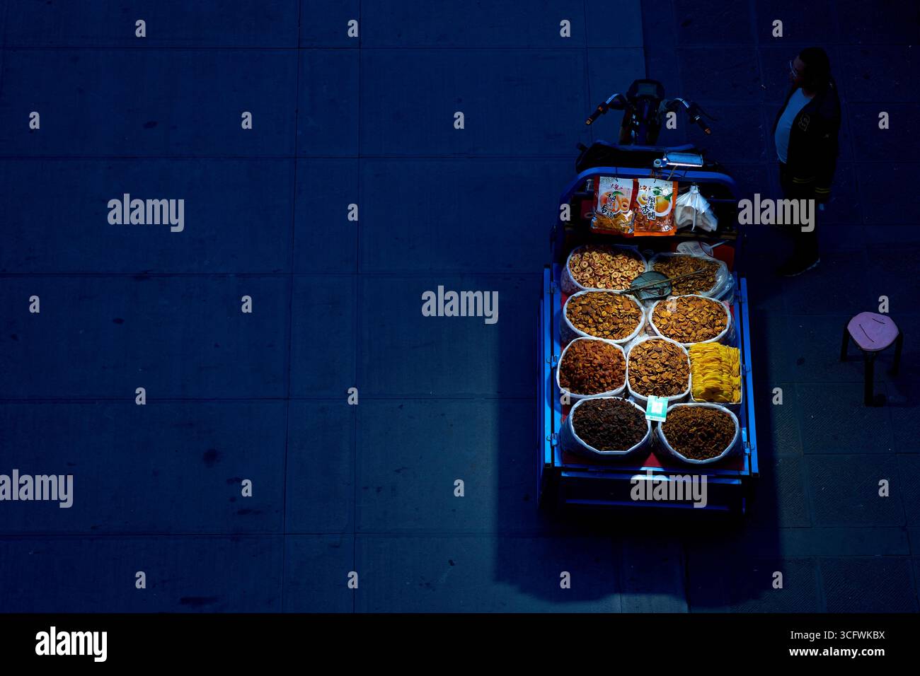 Stalle de nourriture solitaire avec des fruits secs illuminés la nuit à Datong, en Chine Banque D'Images