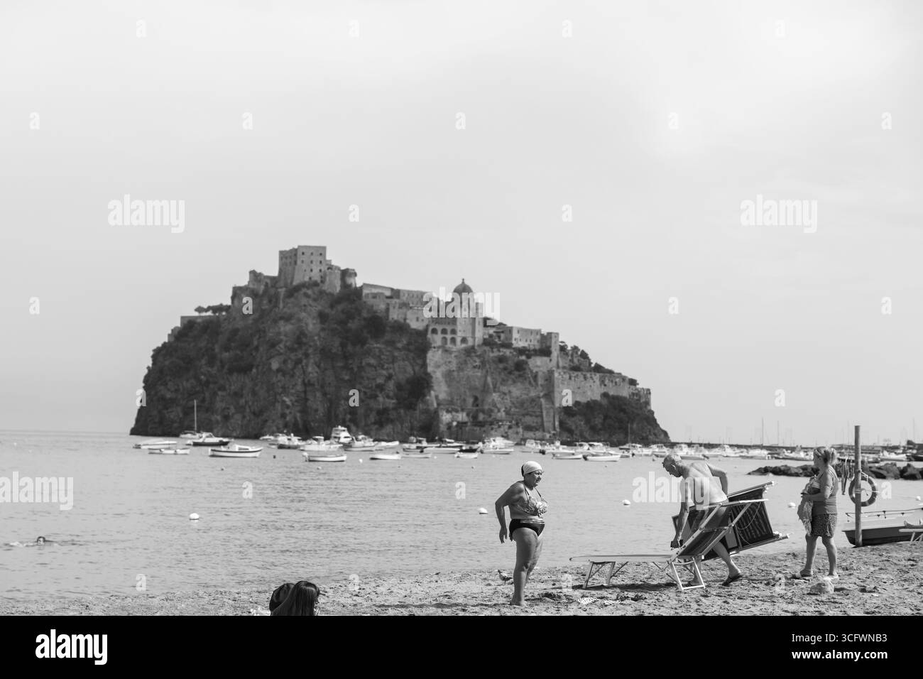 Ischia est une île volcanique dans le golfe de Naples dans le sud de l'Italie. Les gens nagent sur la plage de la Mandra en face du Castello Aragonese d’Ischia Banque D'Images