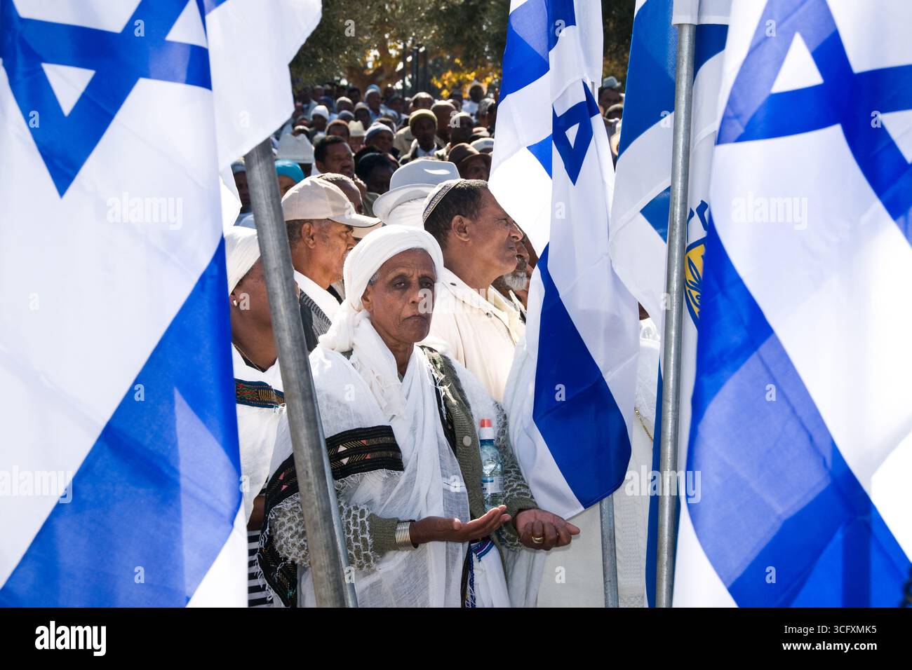 Jérusalem, Israël, 27 novembre 2008 : des drapeaux israéliens entourent une juive éthiopienne vêtue de vêtements traditionnels alors qu'elle prie pendant la célébration annuelle Banque D'Images