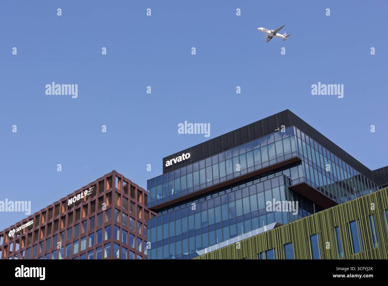 Poznan, Pologne - 16 août 2025 : avion LOT survolant des immeubles de bureaux modernes dans le quartier des affaires Banque D'Images