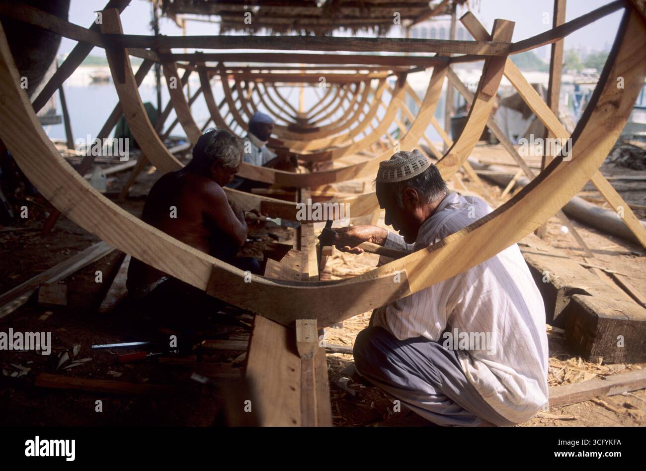 Eau, Abu Dhabi, la construction de bateaux continue de la manière traditionnelle dans les eau, du bois brut à un magnifique boutre. Banque D'Images