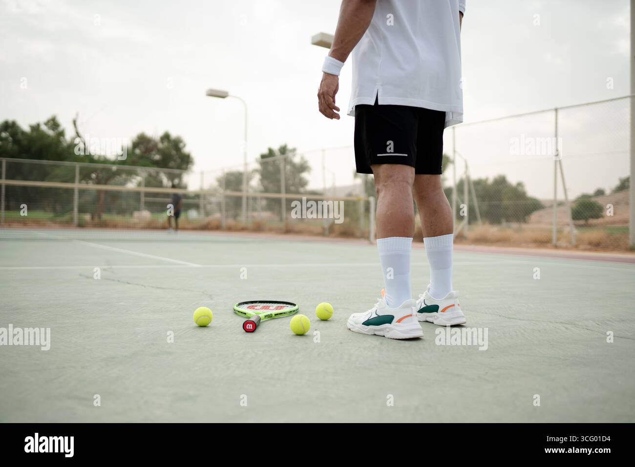 Homme tenant une raquette de tennis sur un court à Riyad, en Arabie Saoudite, représentant l'activité sportive, les loisirs et un mode de vie sain. Banque D'Images