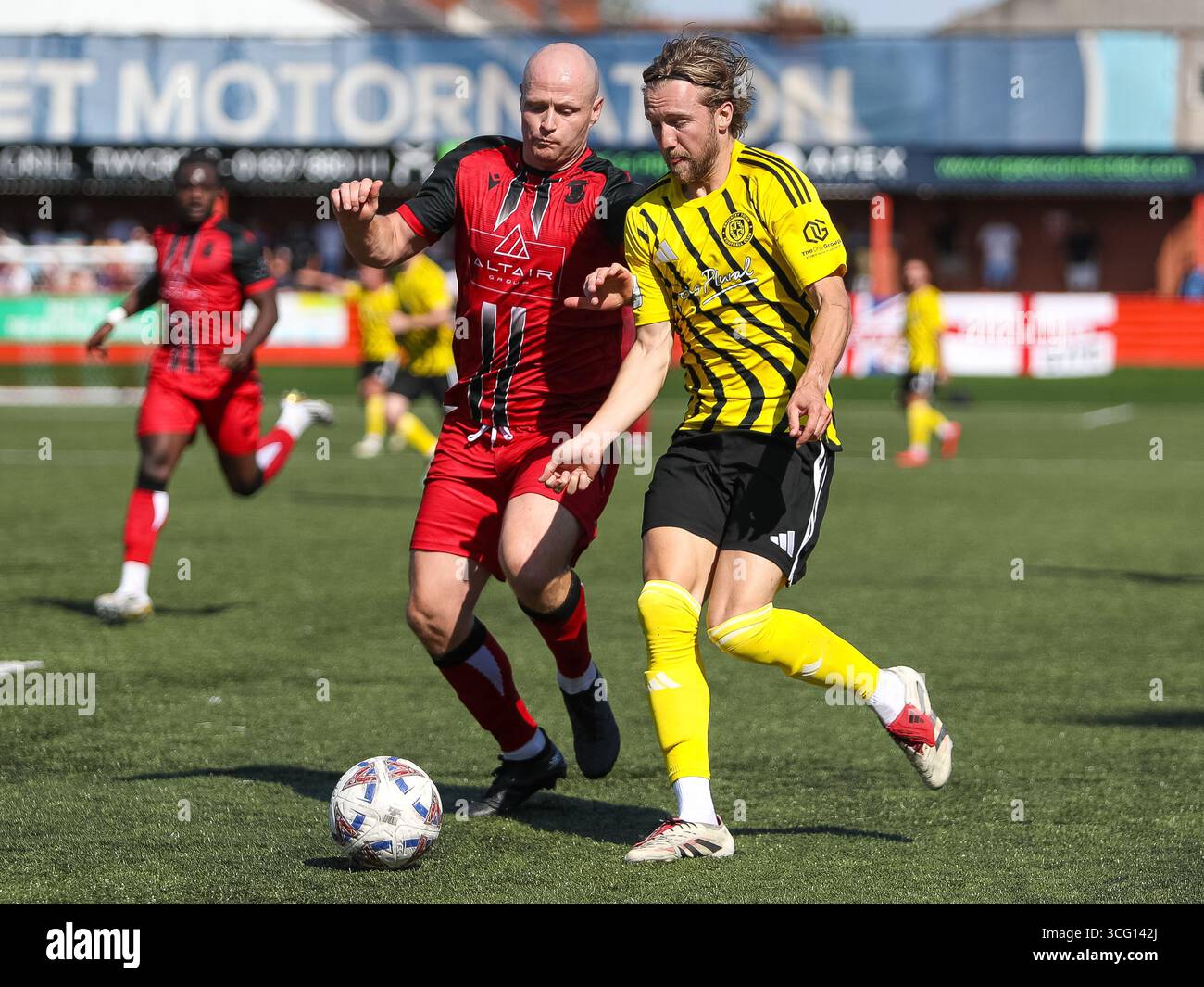 Tamworth, Royaume-Uni. 25 août 2025. Tom Tonks de Tamworth tente de s'attaquer à Morgan Roberts de Brackley Town lors du match entre Tamworth et Brackley Town dans l'Enterprise National League au Lamb Ground, Tamworth. Crédit : Mitch Davidson/Alamy Live News Banque D'Images