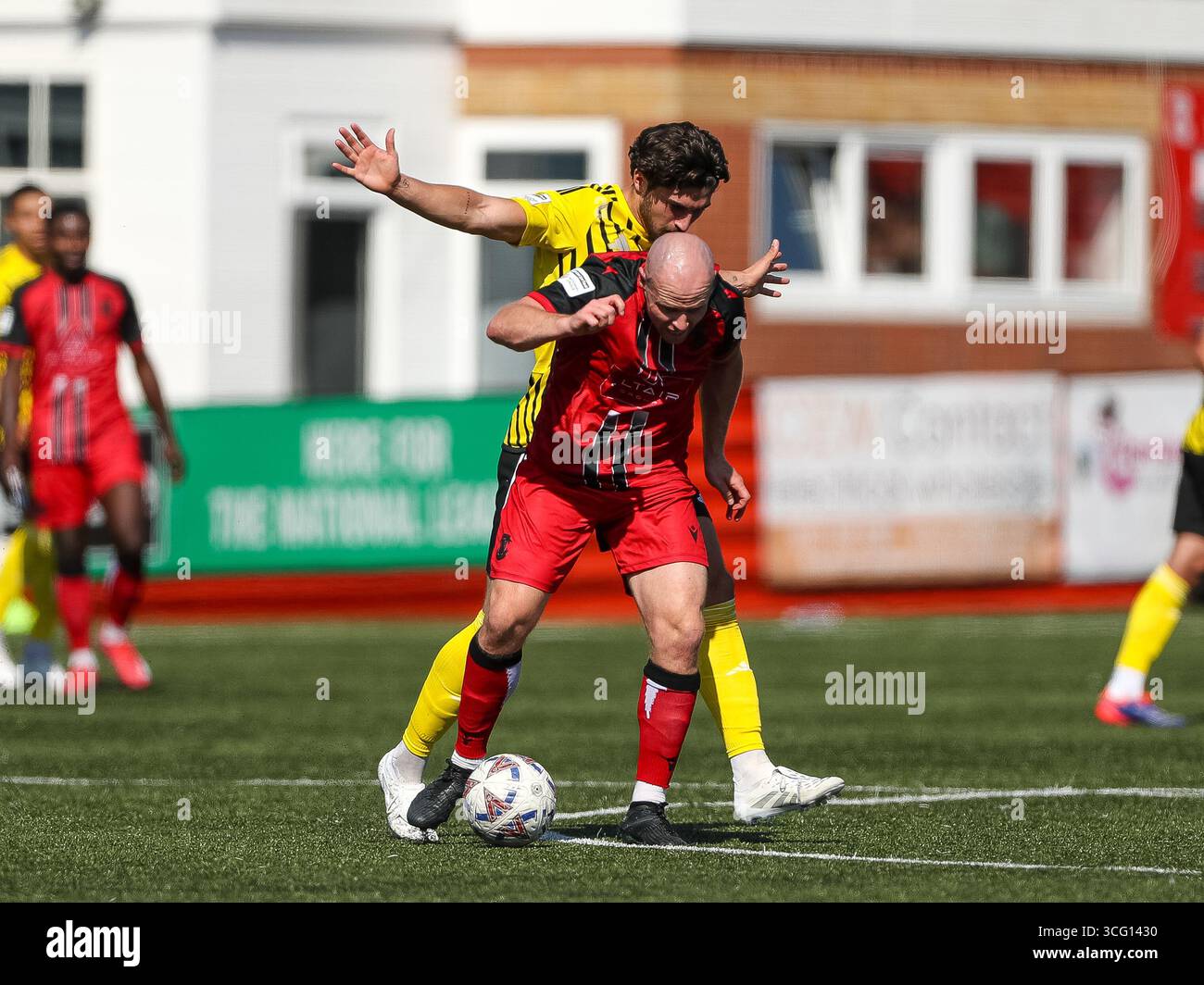 Tamworth, Royaume-Uni. 25 août 2025. Tom Tonks de Tamworth protège le ballon de Scott Pollock de Brackley Town pendant le match entre Tamworth et Brackley Town dans l'Enterprise National League au Lamb Ground, Tamworth. Crédit : Mitch Davidson/Alamy Live News Banque D'Images