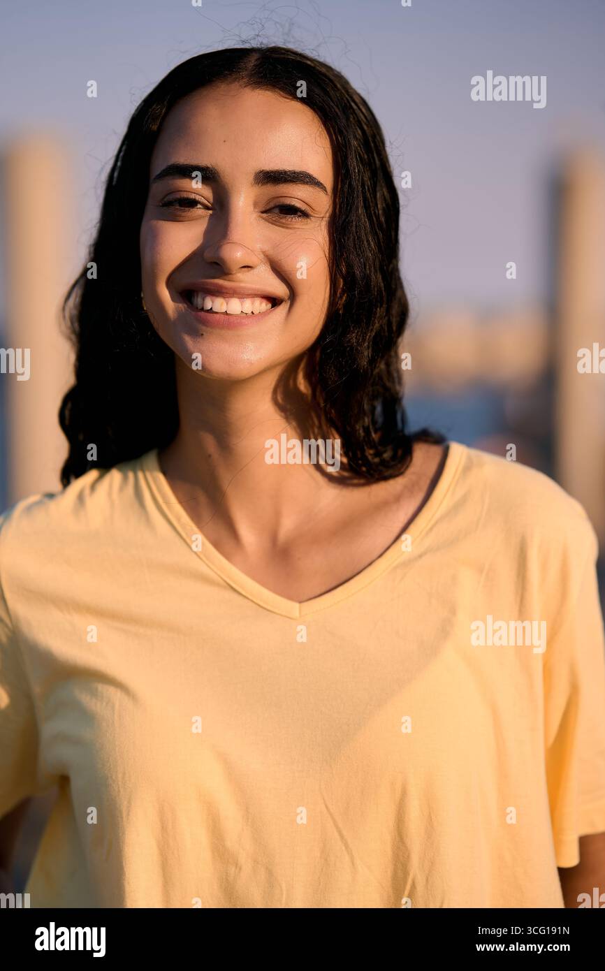 Jeune femme souriant à l'extérieur en milieu urbain Banque D'Images