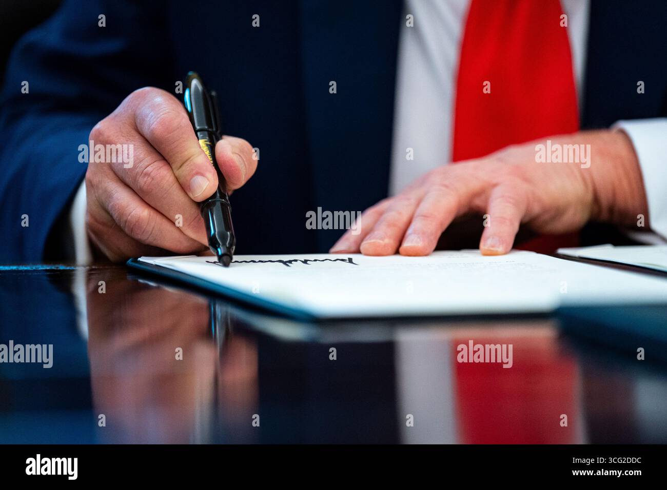 Washington, DC, États-Unis. 25 août 2025. Le président des États-Unis Donald J Trump signe un décret exécutif dans le bureau ovale de la Maison Blanche à Washington, DC, États-Unis, le lundi 25 août, 2025 Trump signe lundi deux décrets visant à mettre fin à la caution sans espèces à Washington et dans tout le pays, marquant la dernière mesure dans le programme de l'administration pour réprimer la criminalité. Crédit : Al Drago/Pool via CNP/dpa/Alamy Live News Banque D'Images