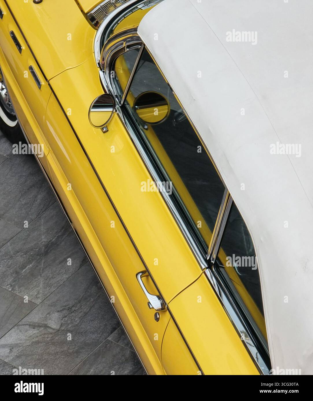Côté gauche de la voiture américaine des années 1960. Cabriolet pleine grandeur jaune avec capote en tissu blanc. Banque D'Images