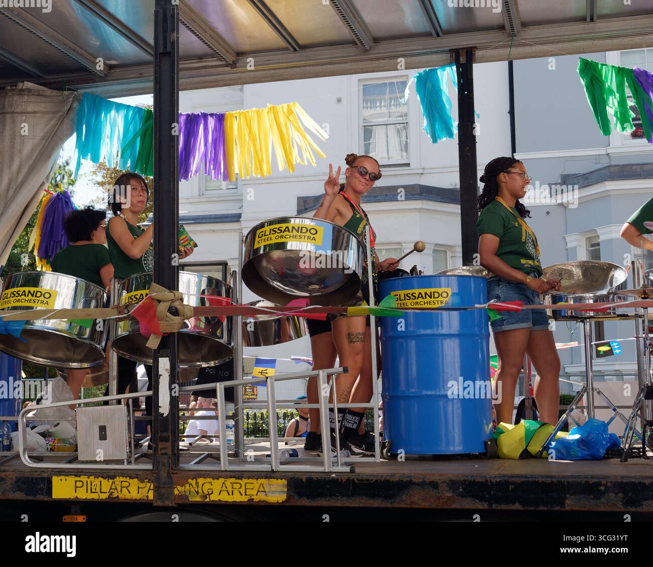 Batteurs féminins sur un flotteur pendant le carnaval de Notting Hill comme on donne un signe de paix. Londres. Angleterre 25 août 2025 Banque D'Images