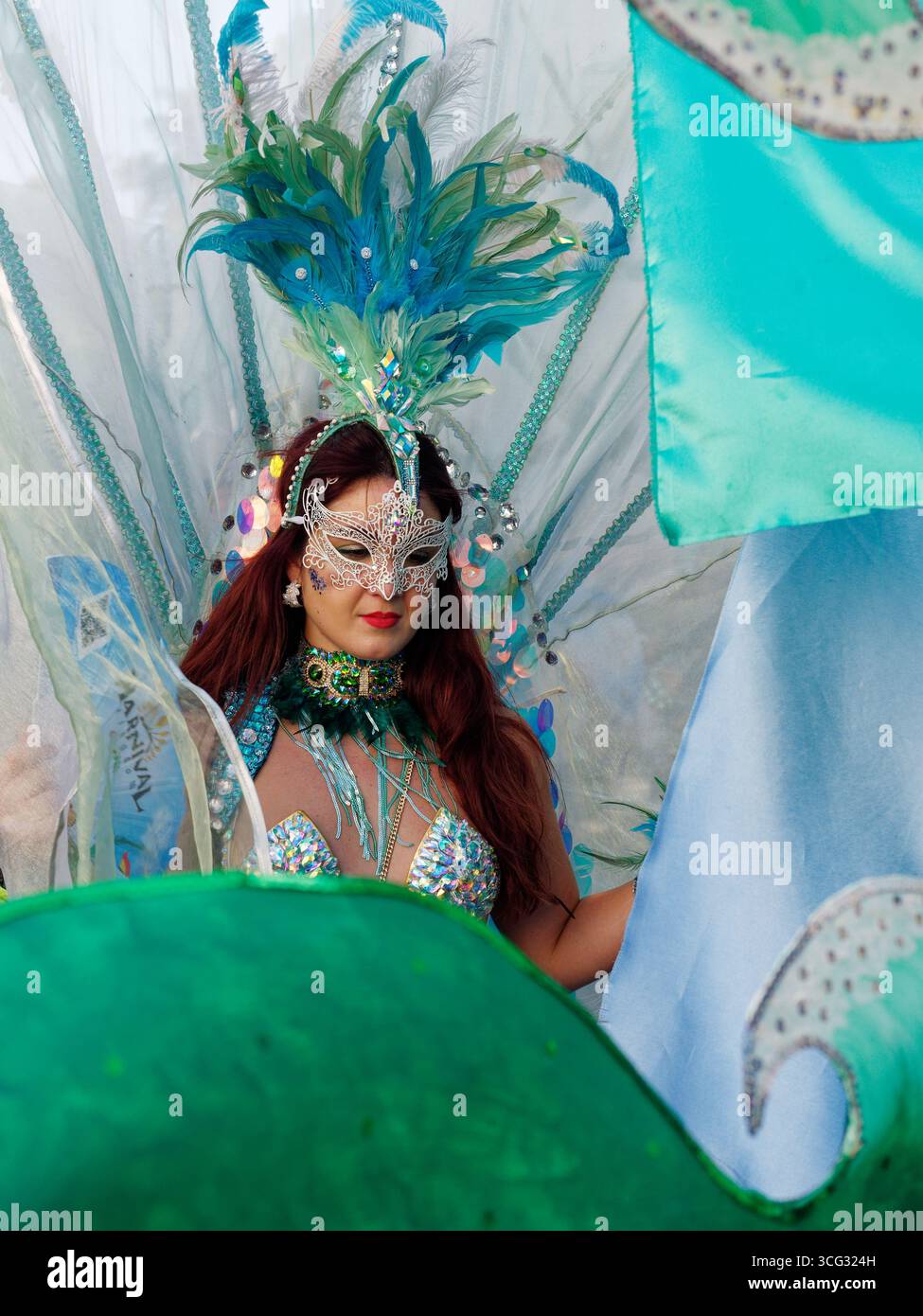 Femme sulfureuse avec coiffe/coiffe bleue et masque argenté et tenue de bikini pendant le Carnaval de Notting Hill, Londres. Angleterre 25 août 2025 Banque D'Images