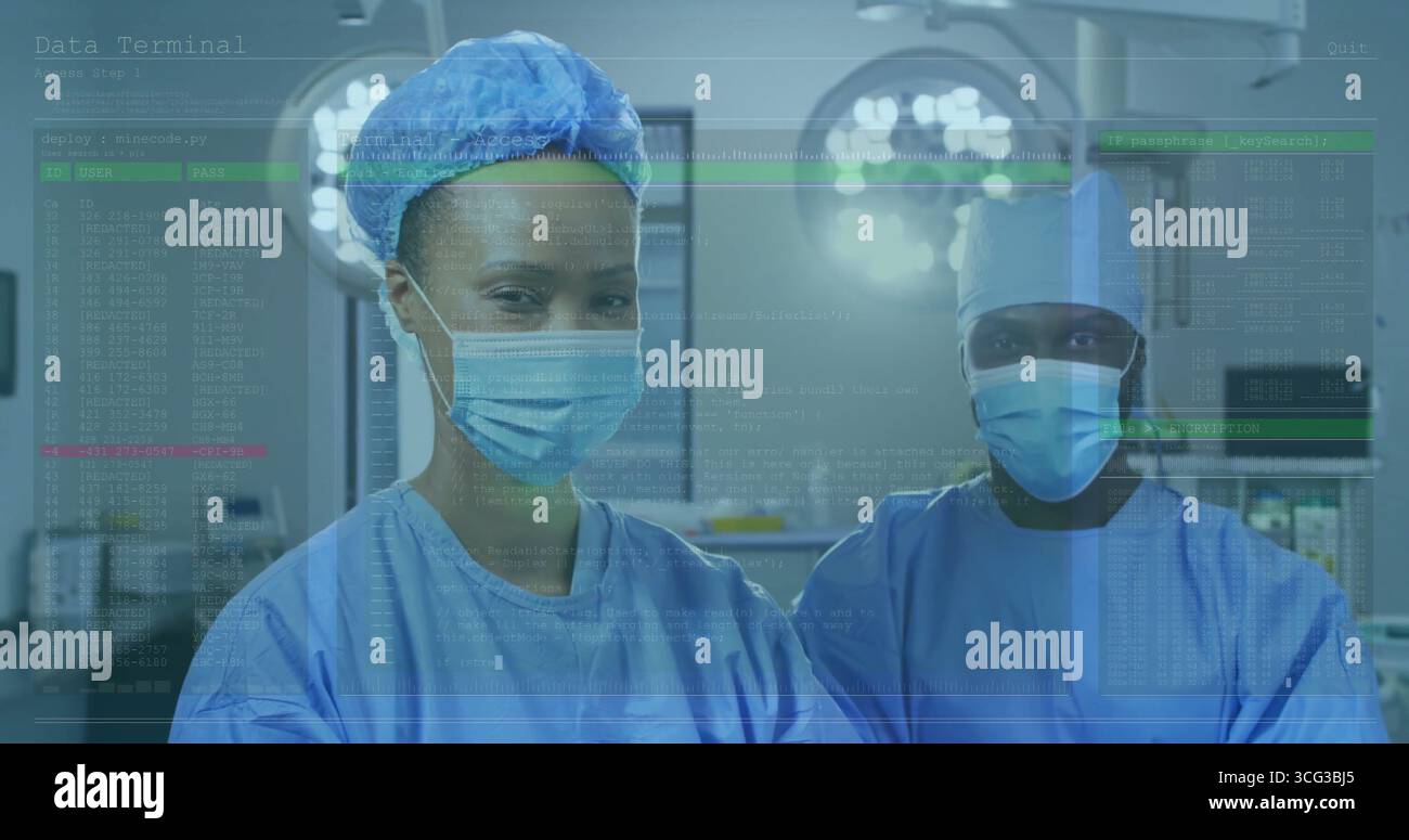 Debout deux chirurgiens dans des gommages bleus examinant les signes vitaux en salle d'opération, avec des lumières et des moniteurs Banque D'Images