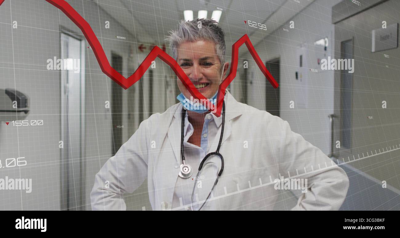 Médecin senior souriant portant blouse de laboratoire et stéthoscope dans le couloir de l'hôpital, avec graphique rouge Banque D'Images