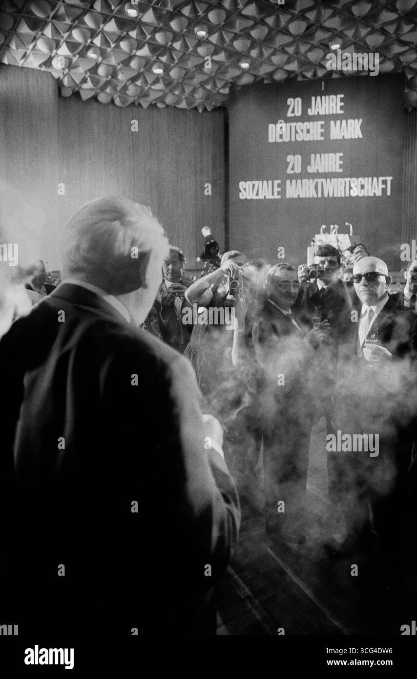 Rückansicht von Ludwig Erhard inmitten von Fotografen und Zigarrenrauch. Schrift über der Bühne : '20 Jahre Deutsche Mark – 20 Jahre Soziale Marktwirtschaft', Bonn im Juni 1968. Banque D'Images