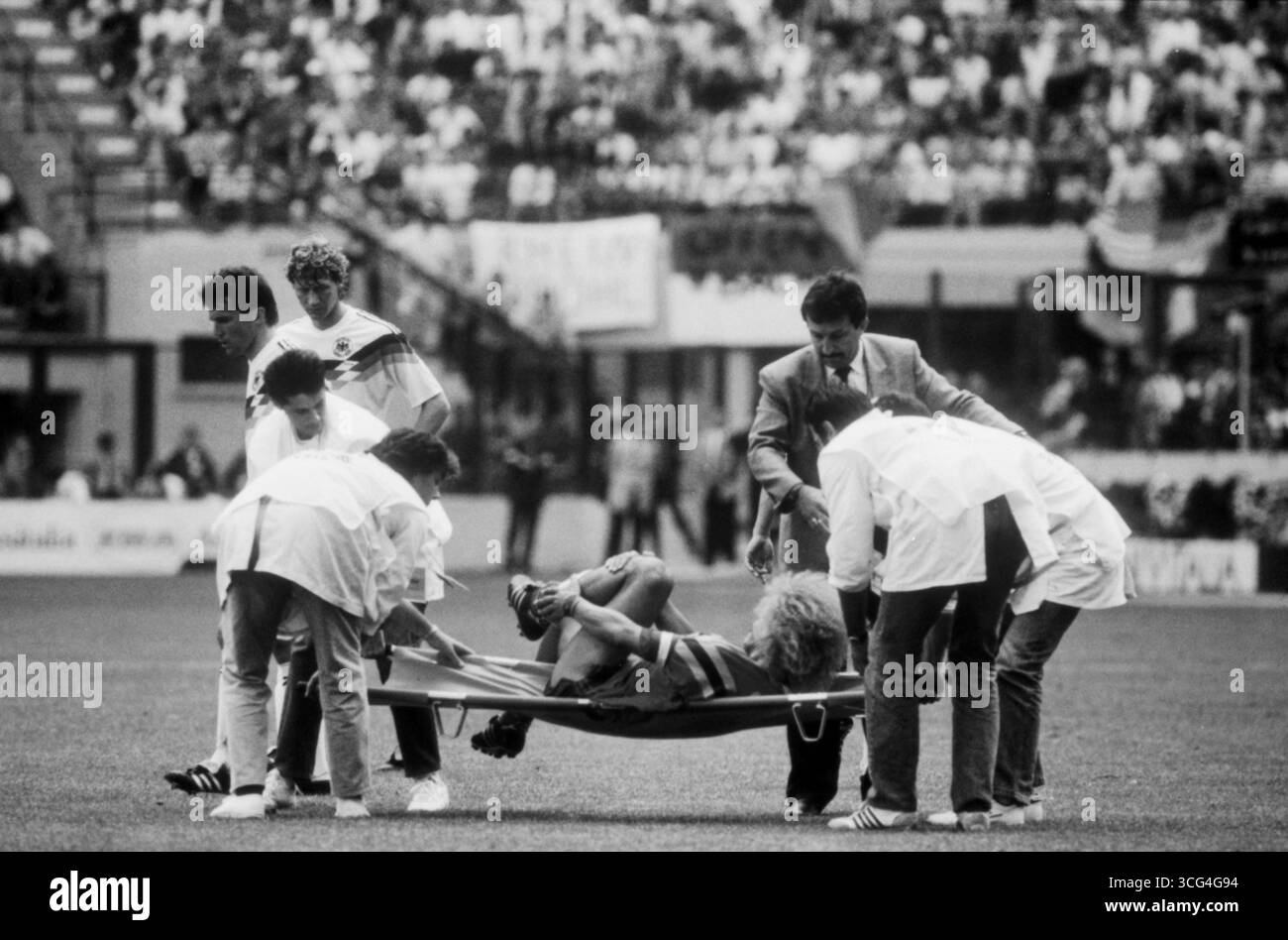 Kolumbiens Spielmacher Carlos Valderrama wird nach einer Verletzung während des WM-Vorrundenspiels gegen Deutschland 1990 auf einer Trage vom Spielfeld gebracht. Banque D'Images
