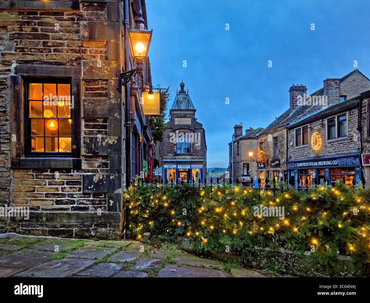 Royaume-Uni, West Yorkshire, Haworth, main Street, Old Post Office et main Street Shops à Noël. Banque D'Images