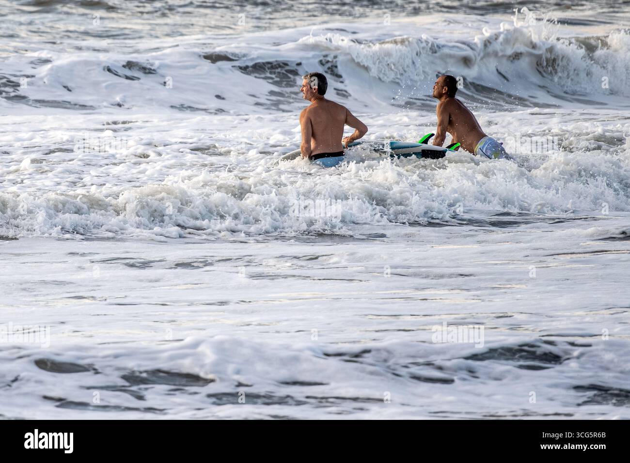 Surfeurs entrant dans l'eau à Fernandina Beach sur l'île d'Amelia dans le nord-est de la Floride. (ÉTATS-UNIS) Banque D'Images