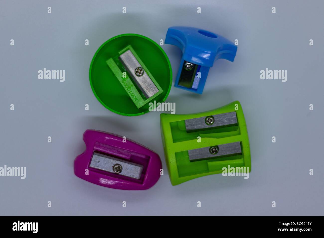 Aiguiseurs en plastique multicolore lumineux pour l'école et le bureau disposés sur une base minimaliste, papeterie vibrante, design fonctionnel. Banque D'Images