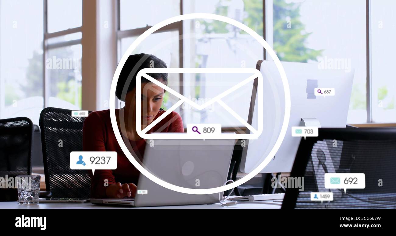 Employé de bureau femme vérifiant les alertes par e-mail sur ordinateur portable au bureau dans le haut Bordeaux avec deux moniteurs Banque D'Images