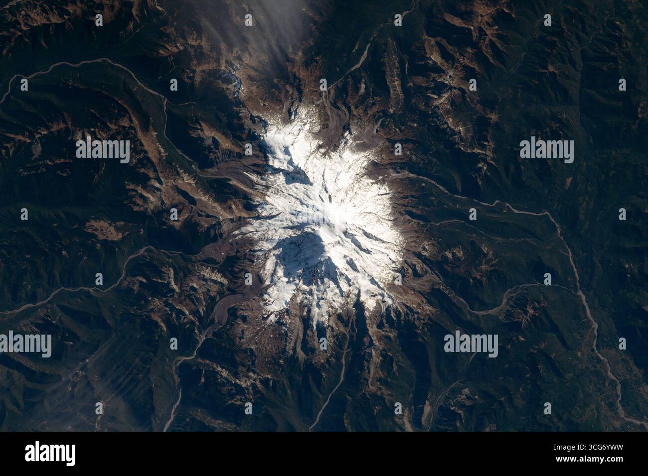 Le mont Rainer, au sommet d'un glacier, monte jusqu'à 14 400 pieds (4 400 mètres) au-dessus du niveau de la mer. En tant que pic le plus glaciaire des États-Unis contigus, le volcan actif traverse le parc national du Mont Rainer, au sud-est de Seattle. La Station spatiale internationale a orbité à 260 milles au-dessus du nord-ouest du Pacifique lorsque cette photographie a été prise. Une version optimisée d'une image originale de l'ISS : crédit : NASA/ESA. Usage éditorial exclusif. Banque D'Images