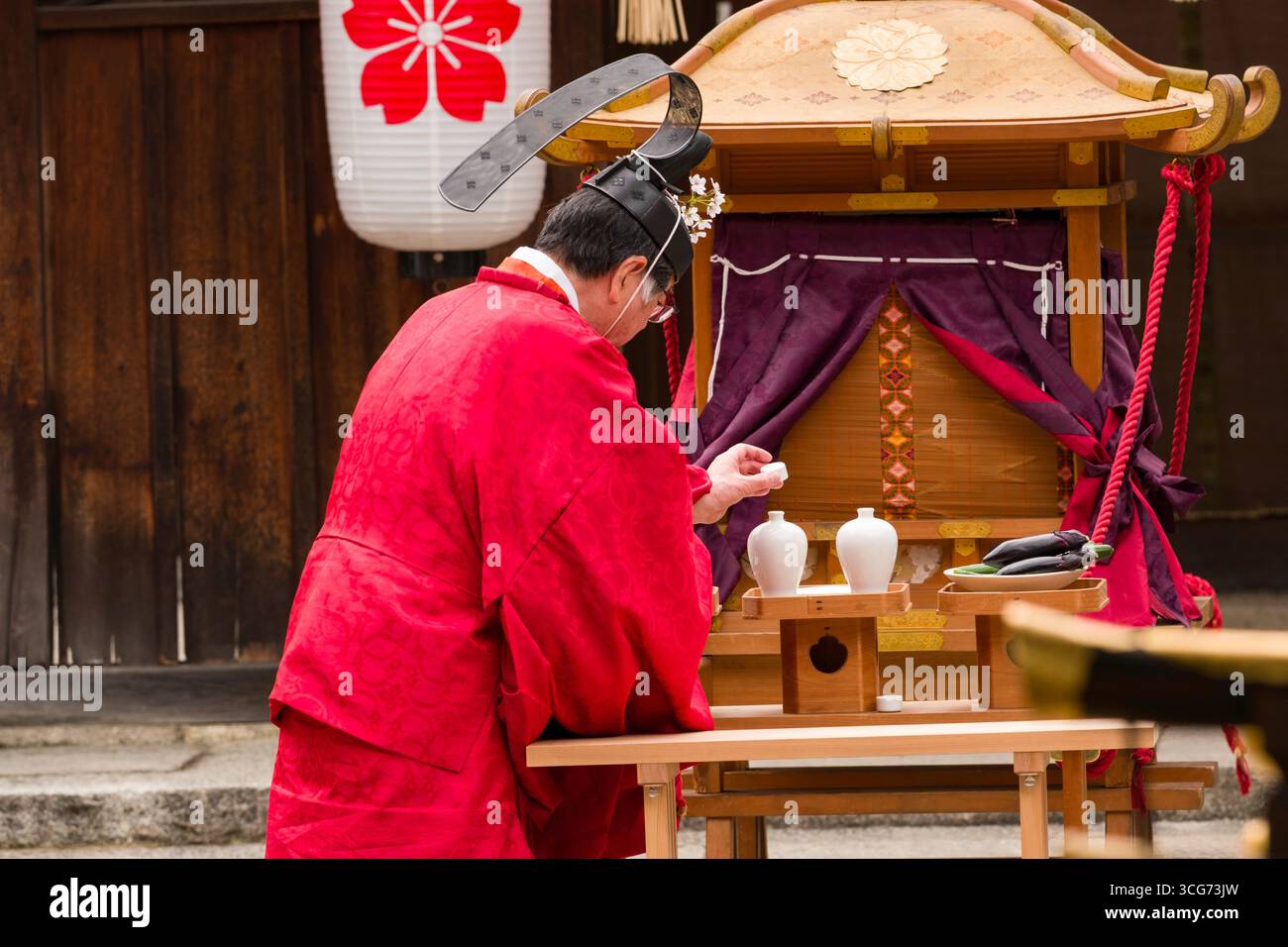 Prêtre shinto enlevant le chapeau de saké offrande pendant le festival Okasai Cherry Blossom au sanctuaire Hirano, Hirano Miyamotocho, quartier Kita, Kyoto, Kansai, Banque D'Images