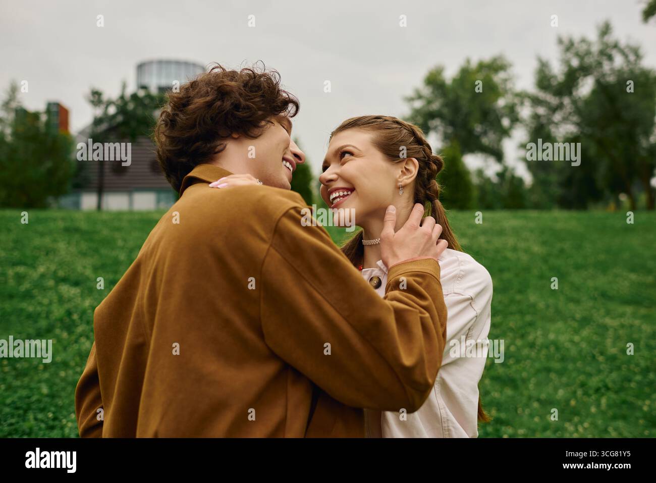 Jeune couple profite d'une promenade heureuse dans un parc verdoyant luxuriant, en se connectant profondément les uns avec les autres. Banque D'Images