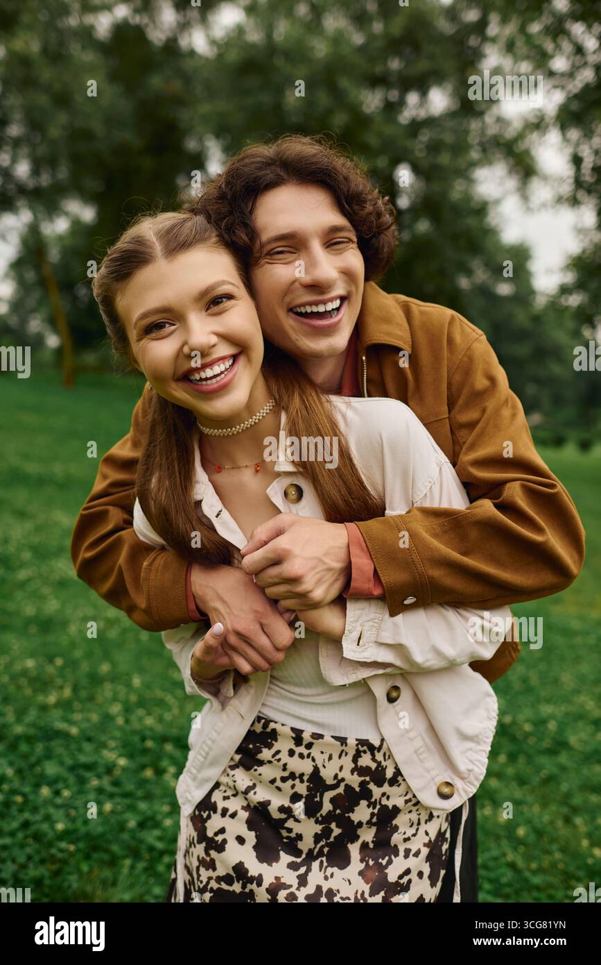 Un couple profite d’un moment de bonheur ensemble tout en se promenant dans un parc verdoyant. Banque D'Images