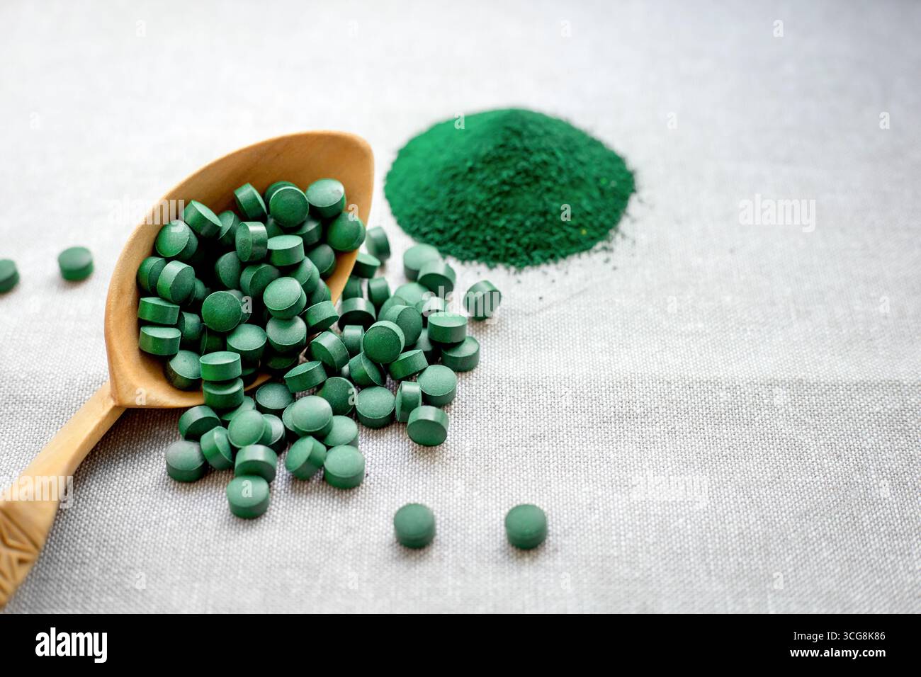 Spiruline d'algues vertes en comprimés et en poudre sur un fond de toile de jute. Protéines végétales. Espace de copie. Protéines végétales saines. Super nourriture Banque D'Images