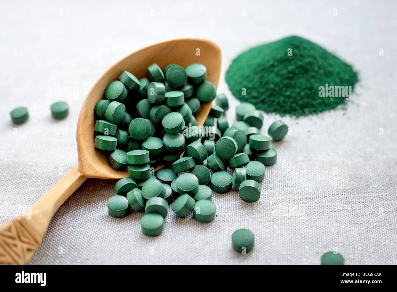 Spiruline d'algues vertes en comprimés et en poudre sur un fond de toile de jute. Protéines végétales Banque D'Images