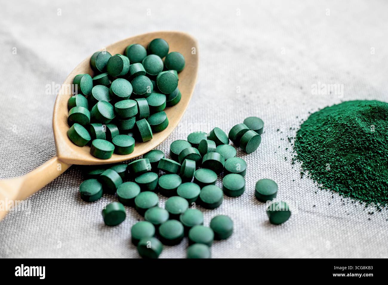Spiruline d'algue verte en comprimés et poudre sur fond gris. Protéines végétales saines. Super nourriture Banque D'Images