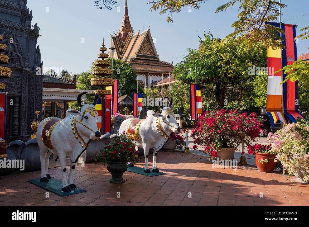 Une paire de vaches blanches sacrées représentées dans l'une des nombreuses sculptures colorées du complexe du temple bouddhiste Wat Preah Prom Rath, Siem Reap, Cambodge Banque D'Images