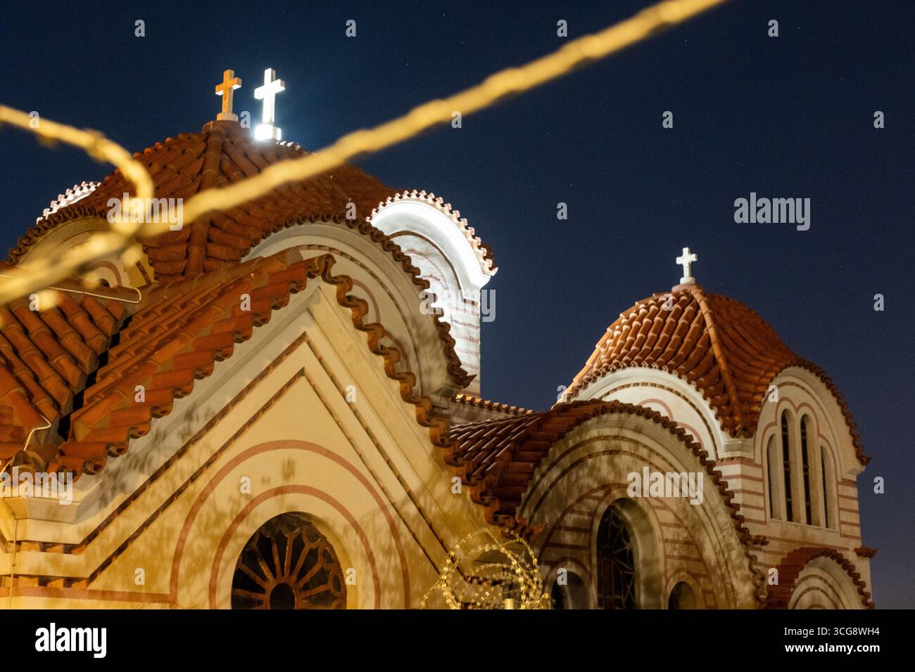 Vue de l'église d'Agioi Anargyroi les toits de tuiles rouges et les croix traversent le ciel sombre, encadré par un fil à Athènes, unité régionale d'Athènes centrale, GRE Banque D'Images