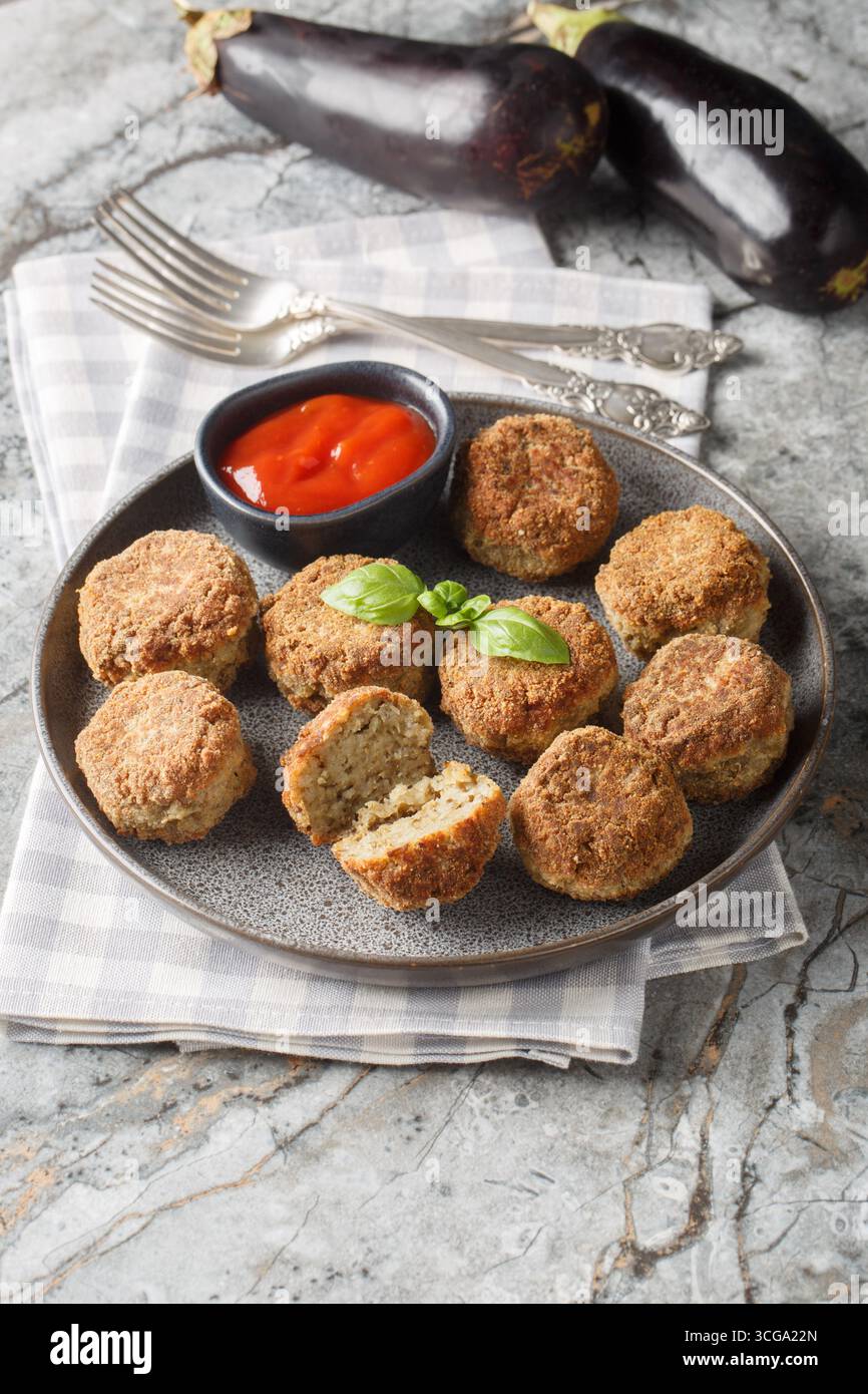 entrée d'aubergines frites boules d'aubergines végétariennes avec sauce tomate et épices gros plan dans l'assiette sur la table. Vertical Banque D'Images